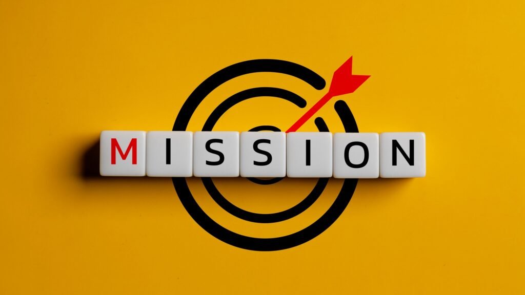 Wooden cubes with the word mission and icon target on a yellow background.